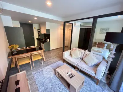 Modern open-plan living room with cozy seating and stylish dining area in a contemporary apartment.