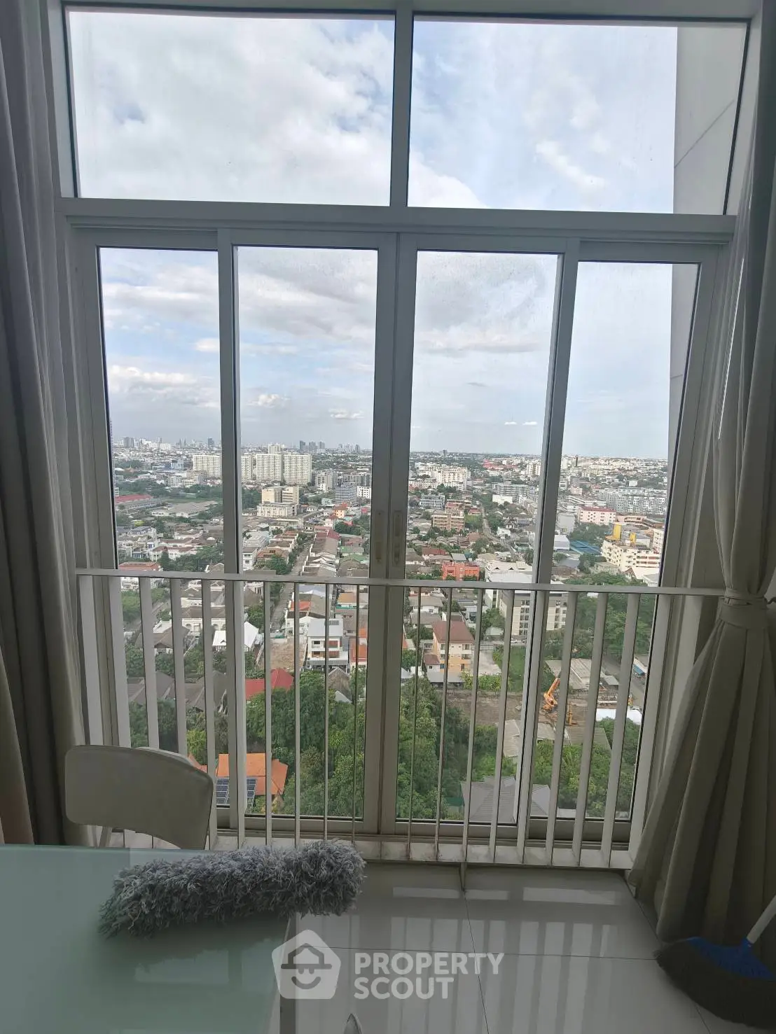 Stunning high-rise apartment view with floor-to-ceiling windows overlooking the cityscape.