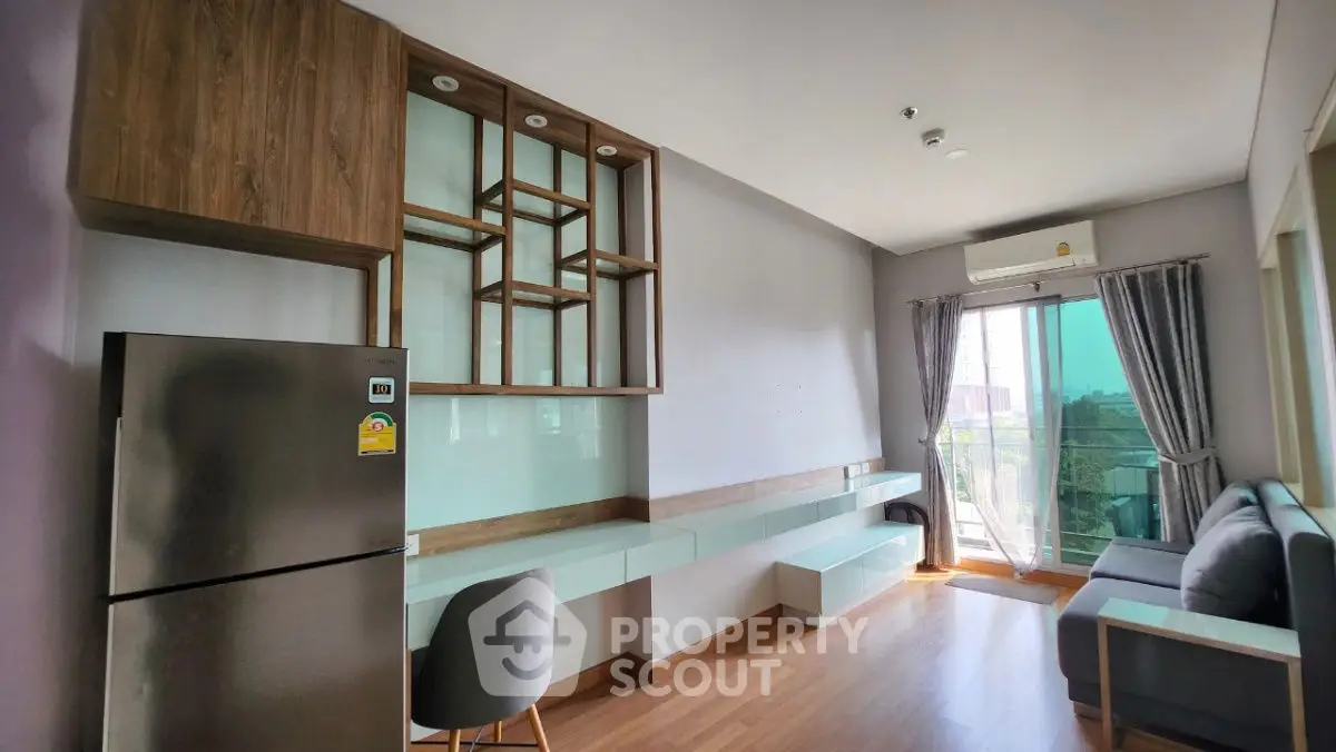 Modern living room with balcony, stylish shelving, and natural light.