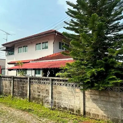 Charming two-story residence surrounded by lush greenery with a spacious balcony and a secure perimeter wall, offering privacy and tranquility.