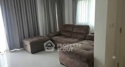 Spacious living room with plush sectional sofa and elegant curtains