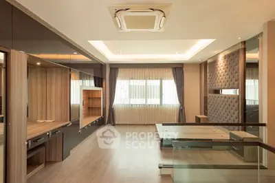Luxurious modern living room with elegant wood finishes and stylish ceiling design.