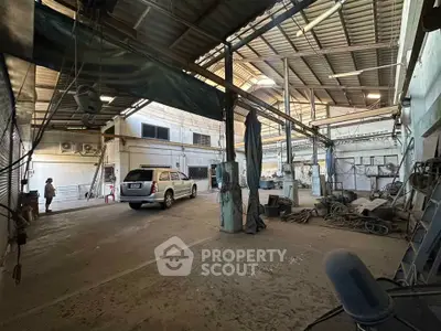 Spacious industrial warehouse with high ceilings and ample parking space.