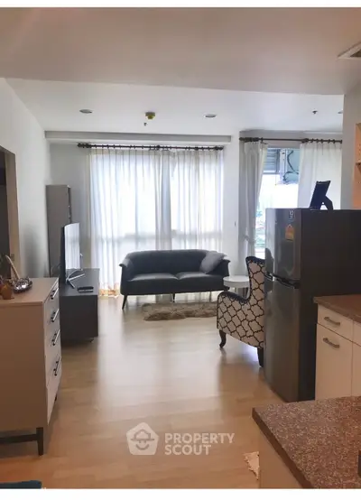 Spacious living room with modern furniture and natural light in a stylish apartment.