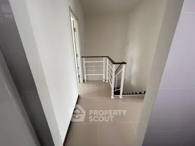 Modern minimalist hallway with sleek staircase and neutral tones