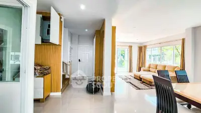 Spacious modern living room with large windows and elegant dining area