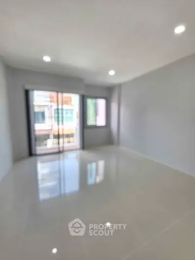 Spacious empty room with large windows and glossy tiled floor