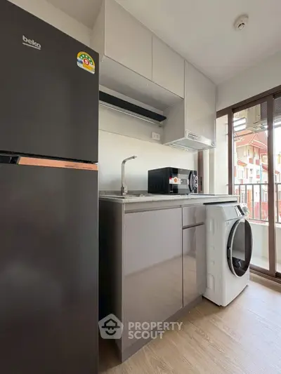 Modern kitchen with appliances and balcony view