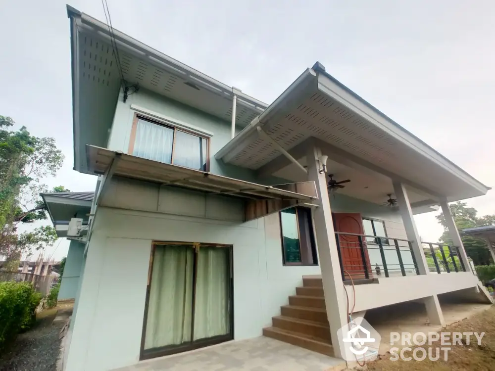 Modern two-story house with elevated entrance and spacious balcony