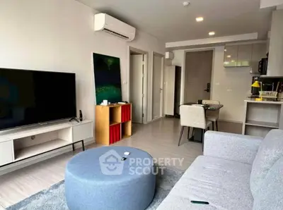 Modern living room with sleek furniture and open kitchen layout in a stylish apartment.