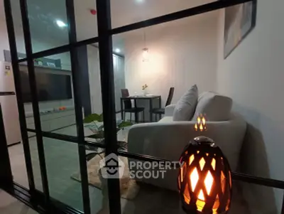 Modern living room with cozy sofa and dining area, featuring stylish decor and ambient lighting.
