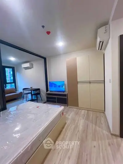 Modern bedroom with sleek design, featuring a bed, wardrobe, and TV in a stylish apartment.