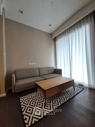 Modern living room with cozy sofa and stylish coffee table, featuring elegant floor-to-ceiling curtains.