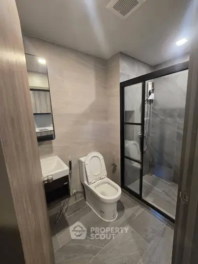Modern bathroom with sleek design featuring glass shower and contemporary fixtures.