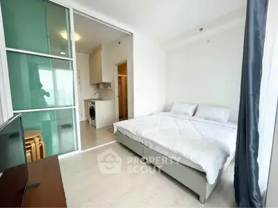 Modern bedroom with sliding glass door and compact kitchen area