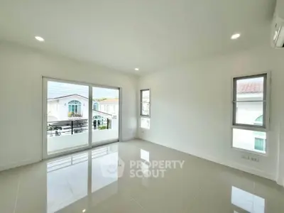 Spacious empty room with large windows and balcony view