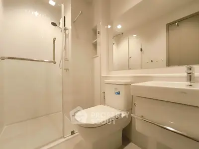 Modern bathroom with glass shower, sleek fixtures, and elegant lighting.