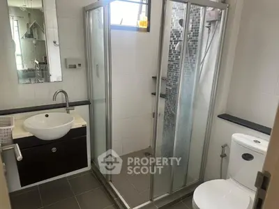 Modern bathroom with glass shower and sleek fixtures in a contemporary home.