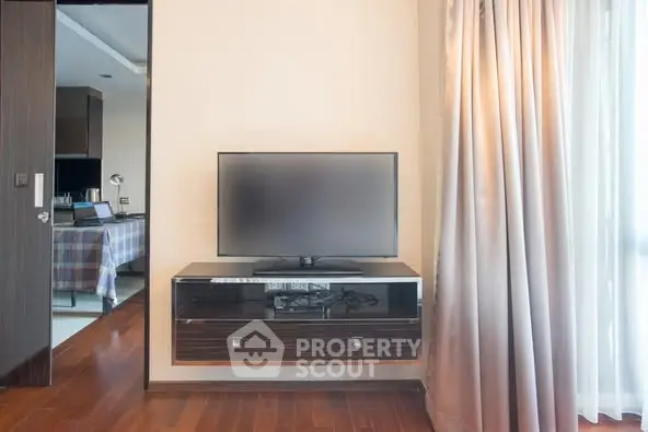 Modern living room with sleek TV setup and elegant curtains