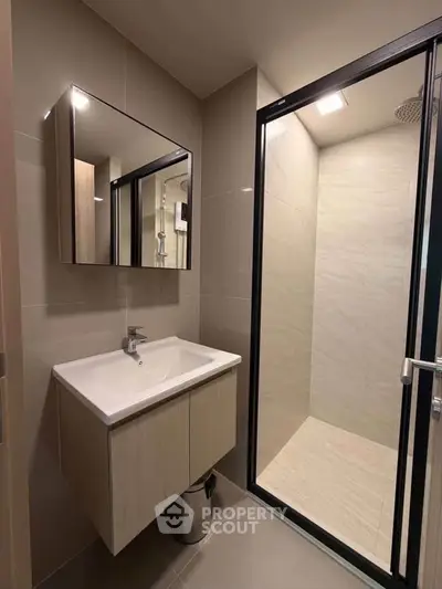 Modern bathroom with sleek vanity and spacious shower in contemporary apartment.