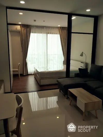 Modern apartment interior with cozy living room and bedroom, featuring elegant furniture and large windows.