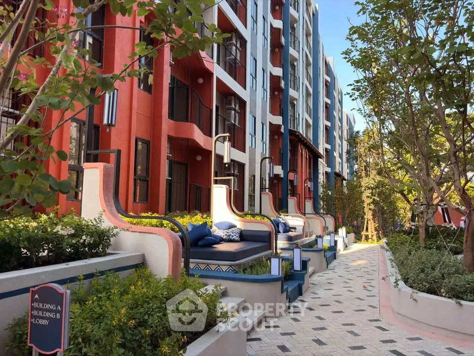 Modern apartment building exterior with stylish outdoor seating and lush greenery