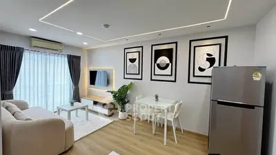 Modern living room with stylish decor, open layout, and natural light, featuring a cozy sofa and dining area.