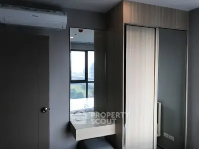 Modern bedroom with built-in wardrobe and air conditioning unit, offering a sleek and functional design.