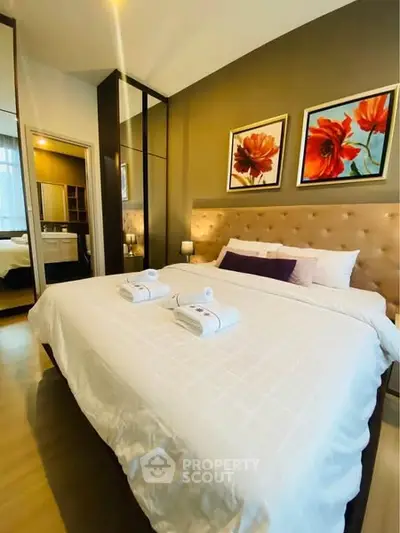 Luxurious bedroom with elegant decor and plush bedding in modern apartment.