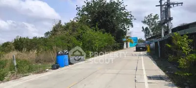 Quiet suburban street with greenery and parked car, ideal for residential development.