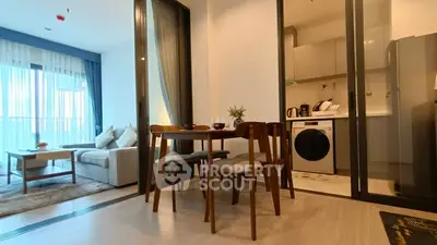 Modern open-plan living room with dining area and kitchen featuring sleek appliances.