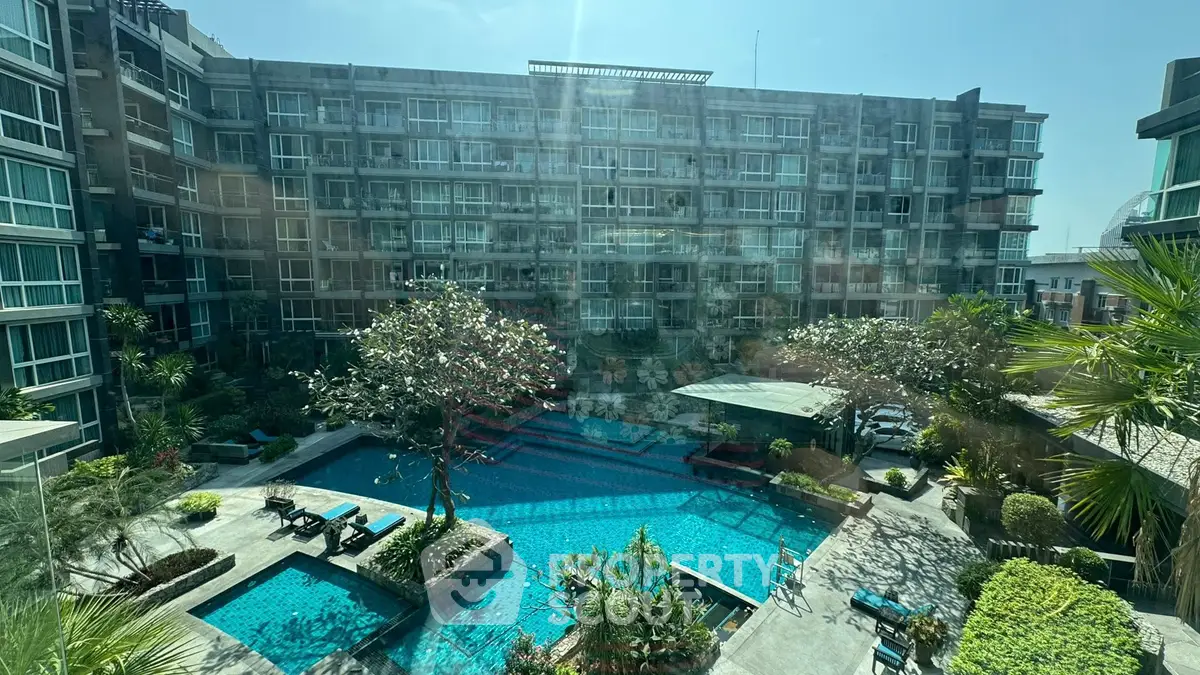 Luxurious residential complex with stunning pool and lush garden view.