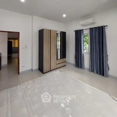 Spacious bedroom with modern wardrobe and air conditioning