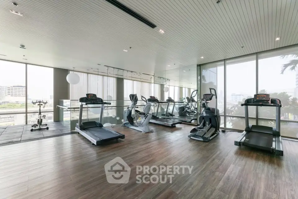 Spacious modern gym with state-of-the-art equipment and panoramic city views.