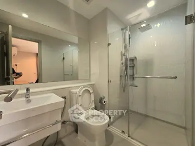 Modern bathroom with glass shower and sleek fixtures in a contemporary apartment.