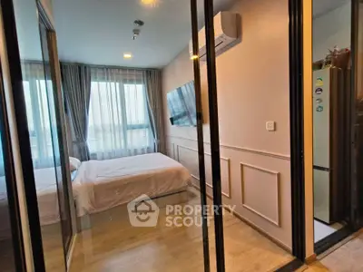 Modern bedroom with glass sliding doors, wall-mounted TV, and air conditioning unit.