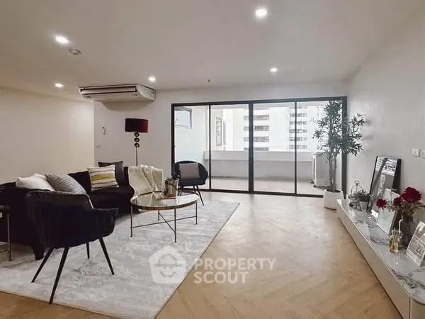 Spacious modern living room with large windows and balcony access in urban apartment.