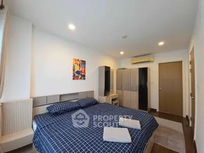 Spacious bedroom with modern decor and ample storage in a stylish apartment.