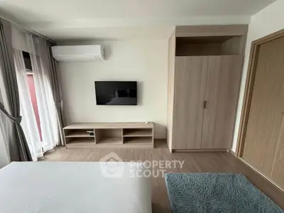 Modern bedroom with sleek design, featuring a wall-mounted TV and stylish wooden furniture.