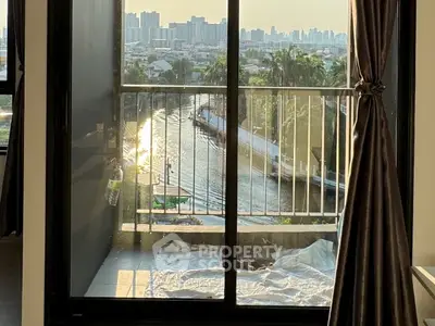 Stunning city view from a cozy balcony overlooking a serene river at sunset.