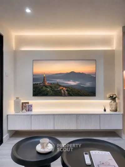 Modern living room with stylish decor and large wall-mounted TV displaying scenic landscape.
