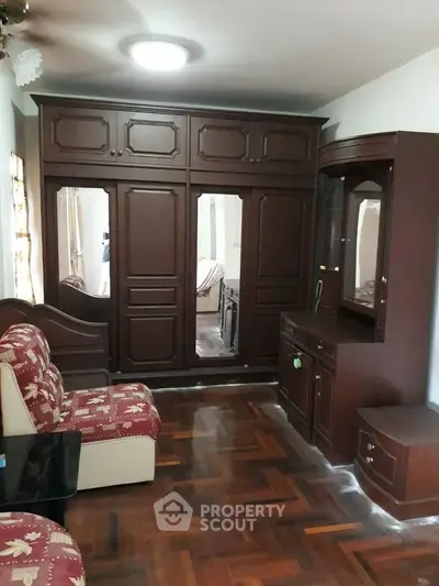 Spacious bedroom with elegant wooden furniture and parquet flooring