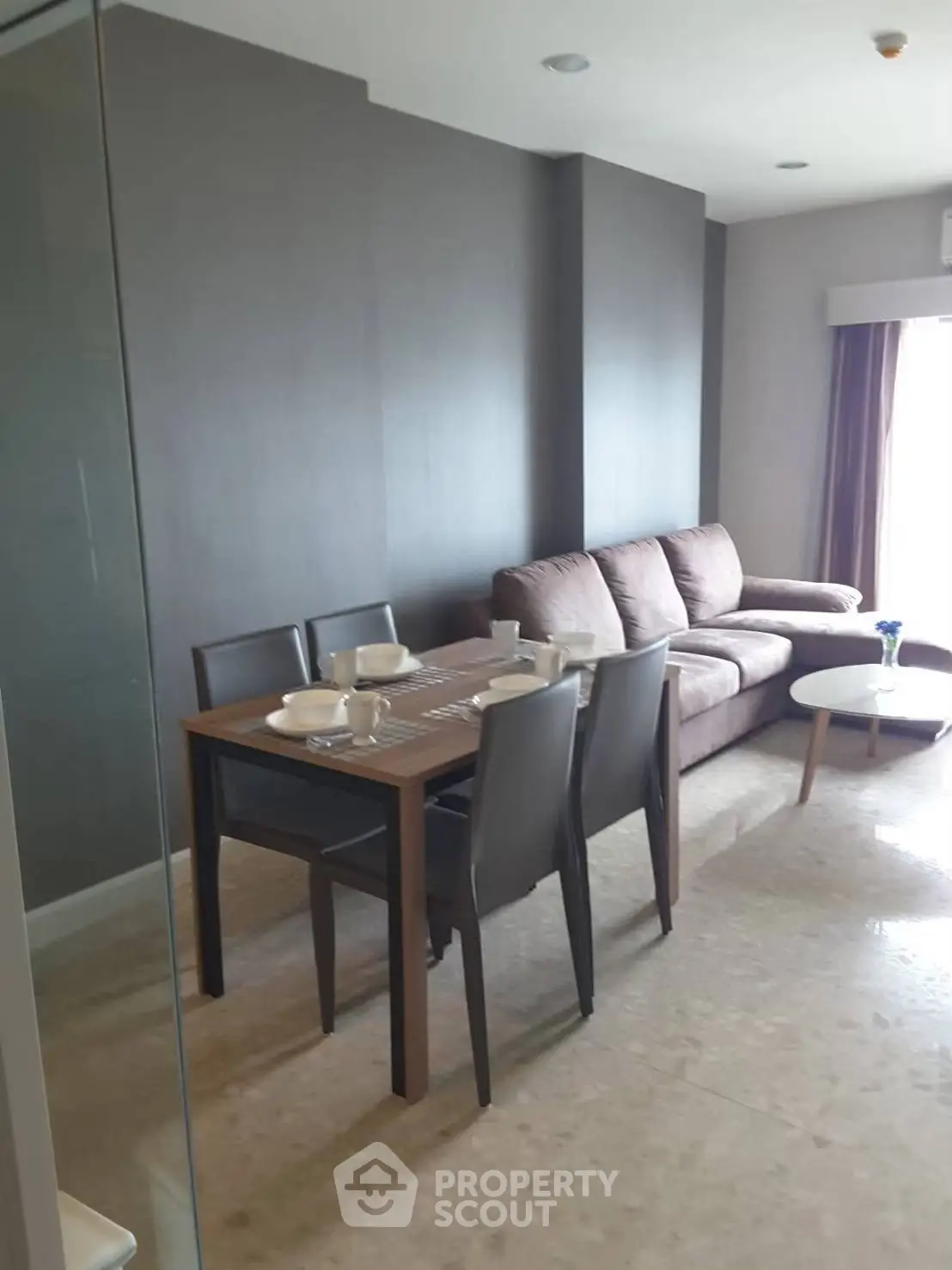 Modern living room with stylish furniture and dining area in a cozy apartment.