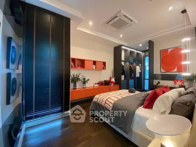 Modern bedroom with stylish decor and ample storage space, featuring a cozy bed and contemporary lighting.