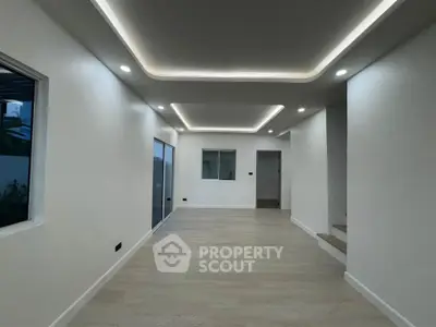 Spacious modern living room with sleek lighting and wooden flooring