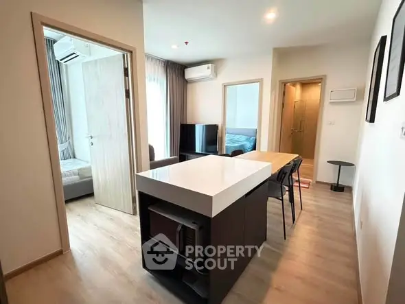 Modern apartment interior with open layout, featuring a sleek kitchen island and cozy living area.