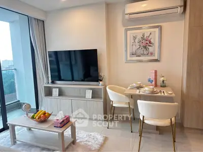 Modern living room with stylish decor and large TV, featuring a cozy dining area and balcony view.