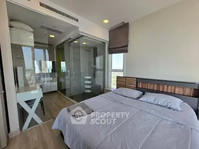 Modern bedroom with glass-walled bathroom and city view