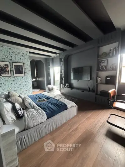 Modern bedroom with stylish decor and wooden flooring, featuring a cozy bed and wall-mounted TV.