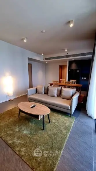Spacious modern living room with cozy sofa and dining area, perfect for relaxation and entertaining.
